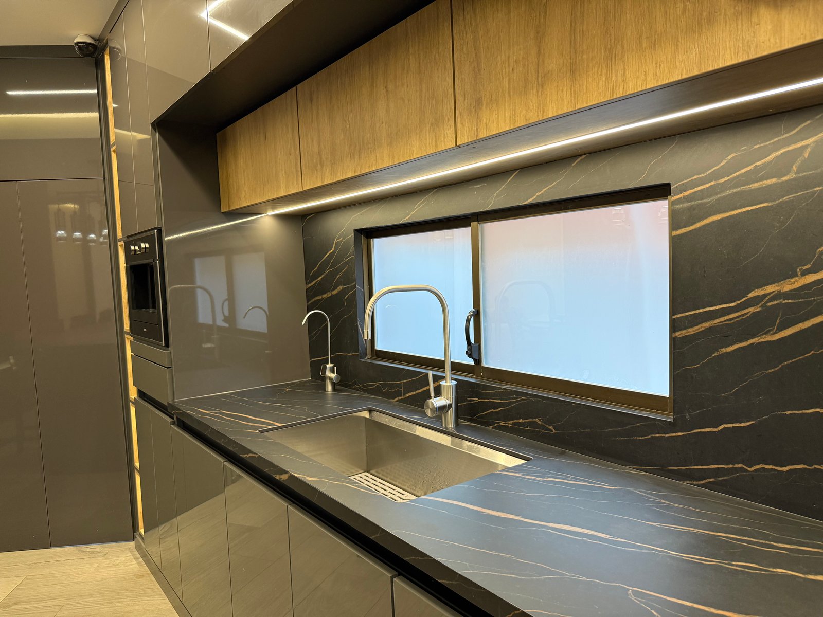 Kitchen sink, dark stone countertops and built-in cabinetry