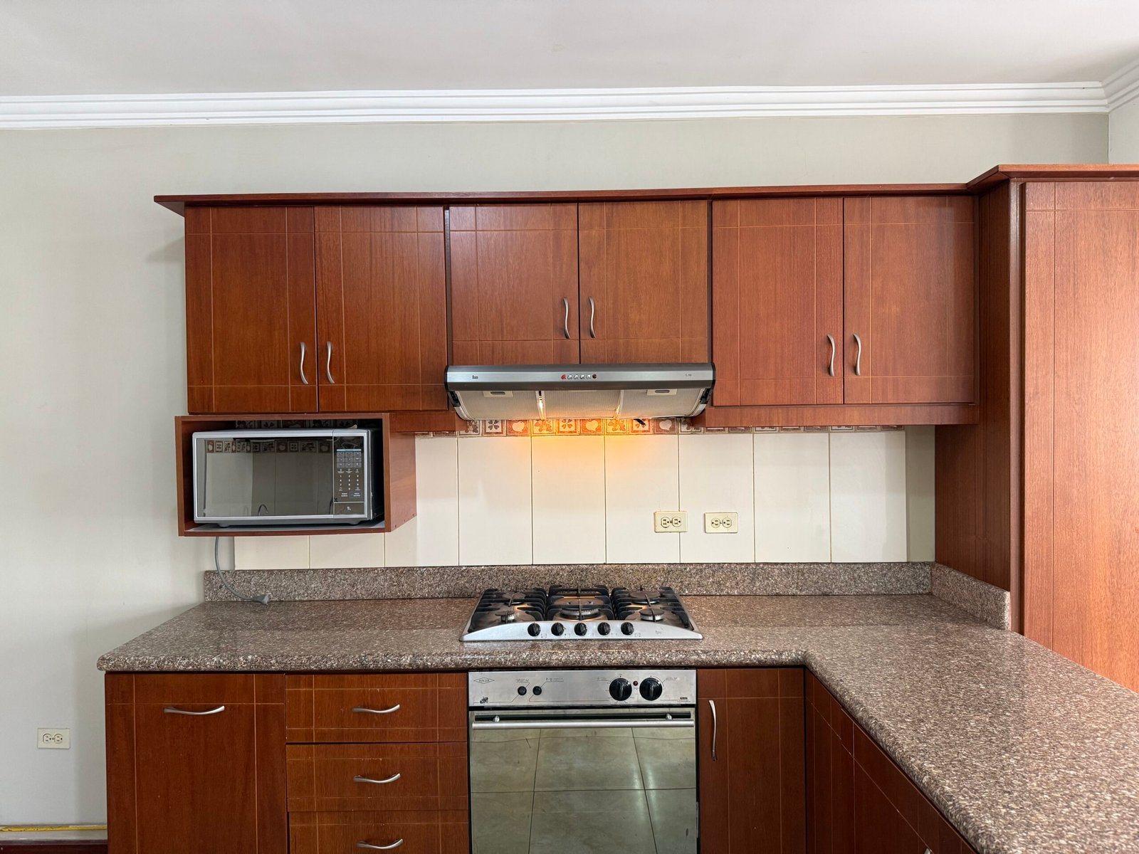 Fitted kitchen with wood cabinetry and granite countertops