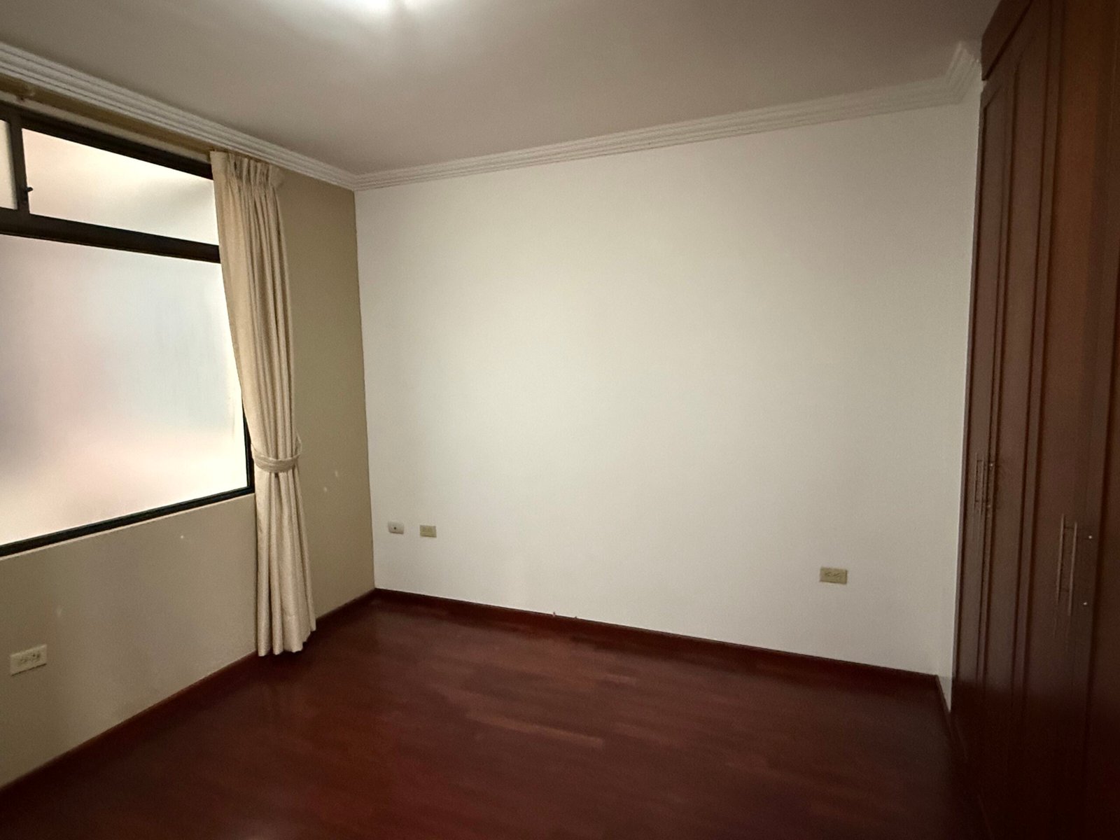 Additional bedroom with hardwood flooring and natural light