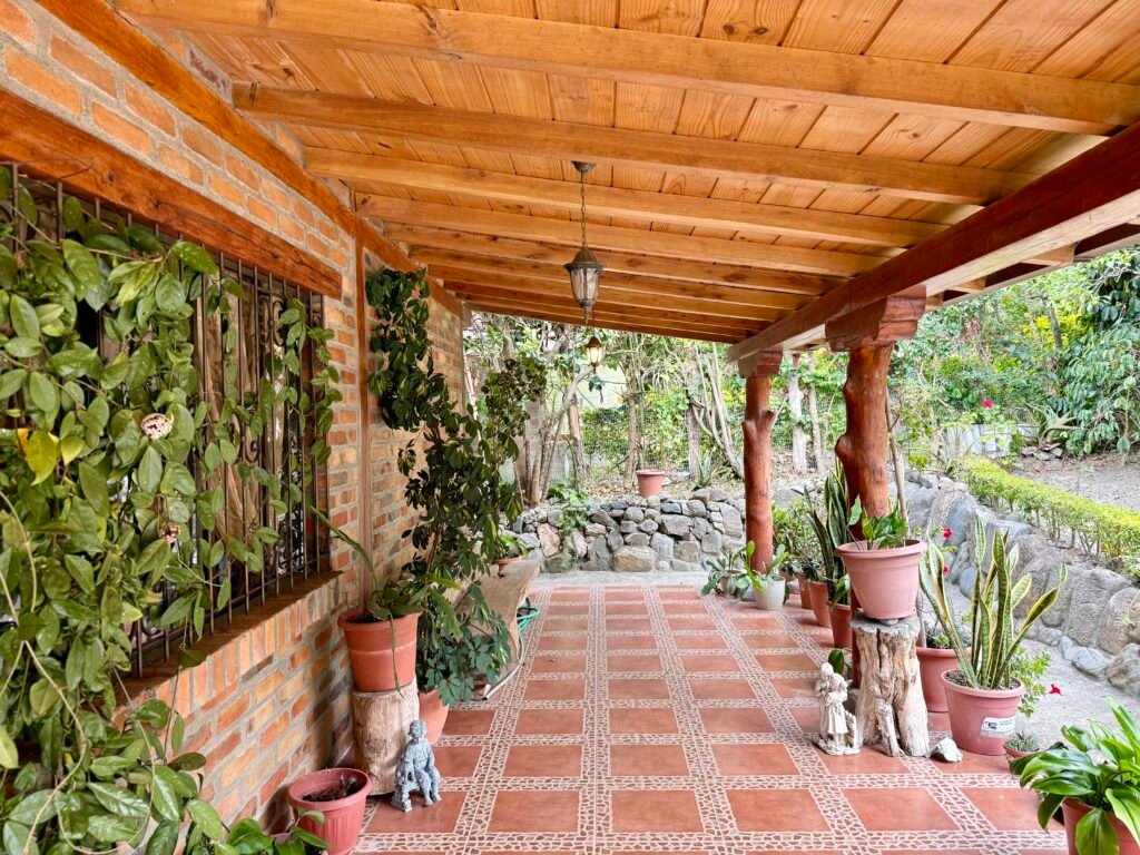 Covered outdoor dining area beside the garden