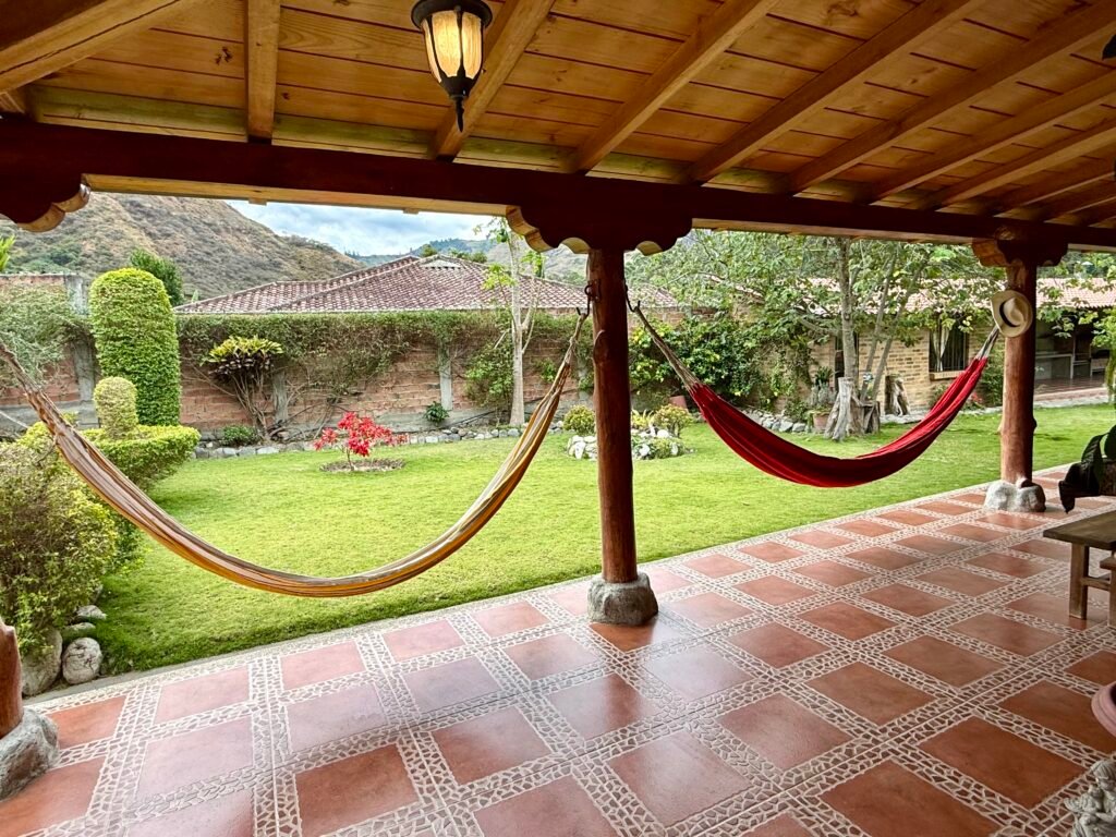 Covered patio with a hammock and garden views