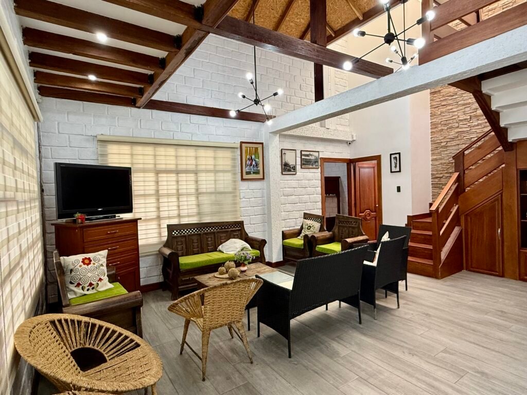 Living room with high ceilings and open wooden staircase