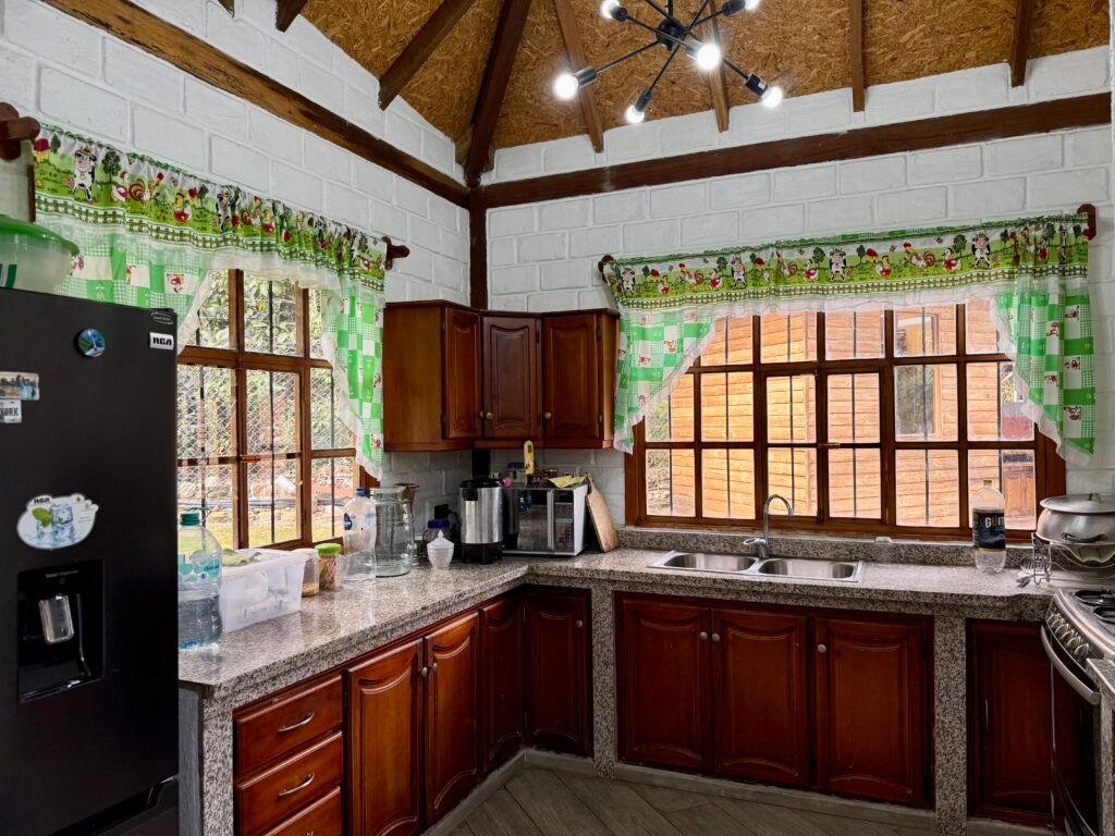 Kitchen with wood cabinetry, granite countertops and large windows