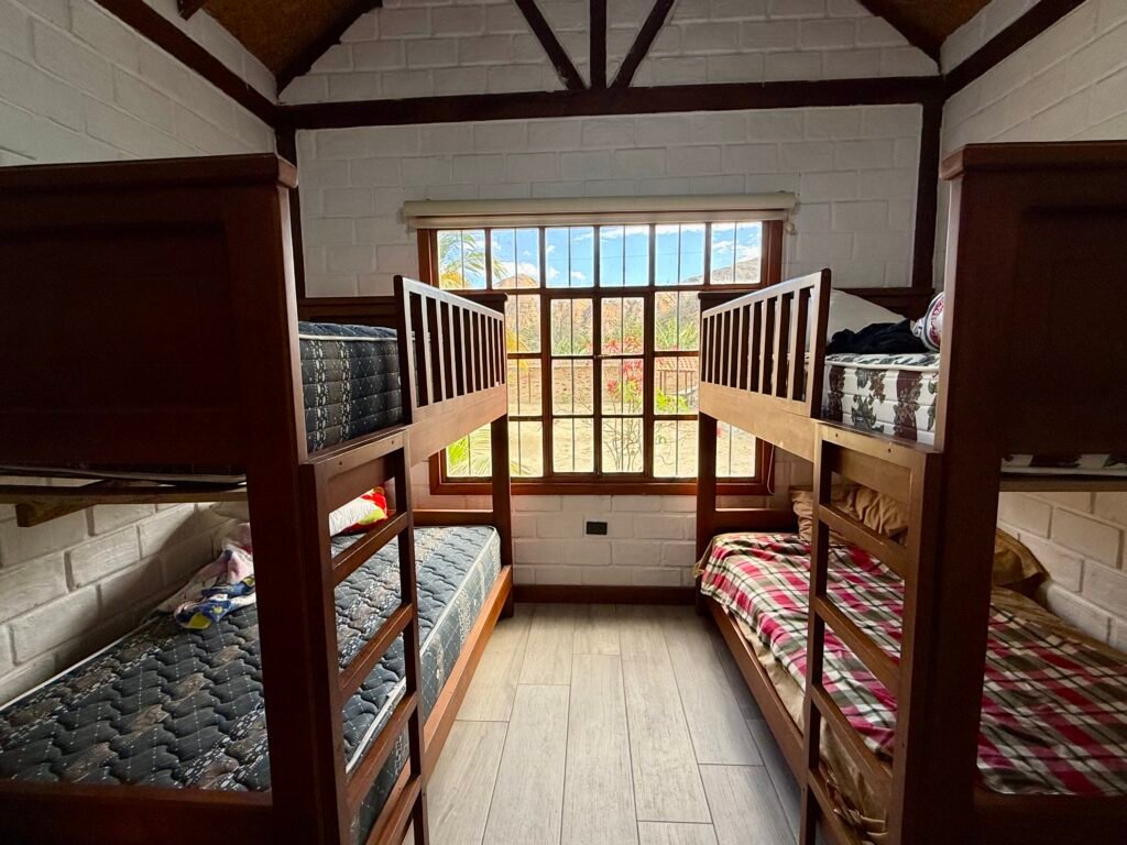 Bedroom with two wooden bunk beds and a large window