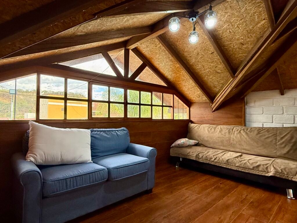 Loft seating area beneath a sloped wooden ceiling