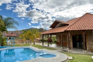 Exterior of the hacienda-style home with swimming pool and mountain backdrop