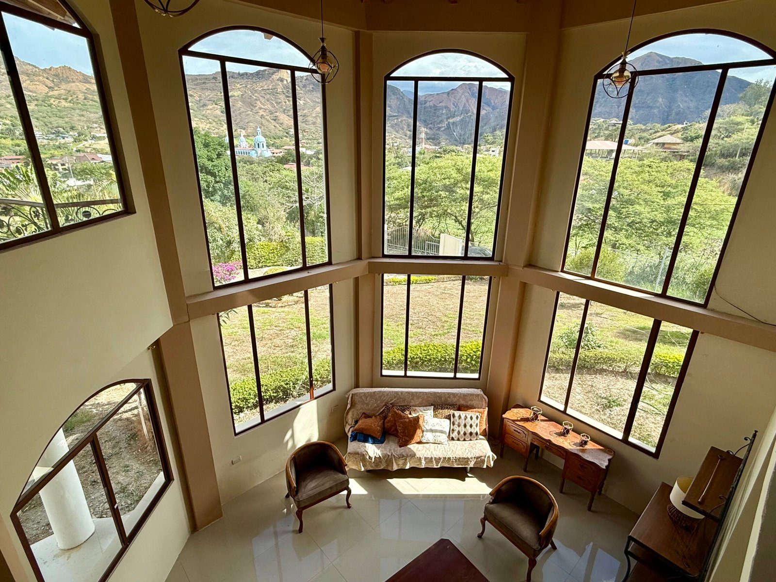 Tall arched windows overlooking the green surroundings