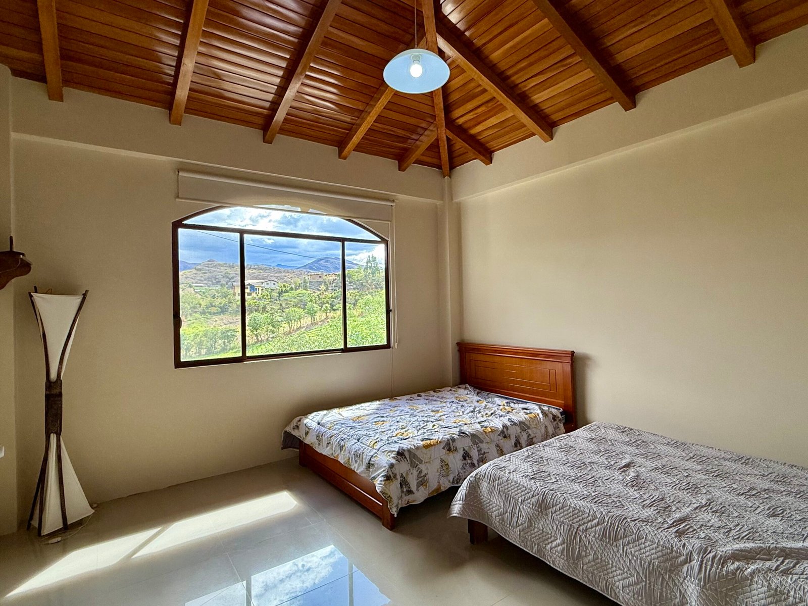 Arched window in an upper-level wood-beamed room