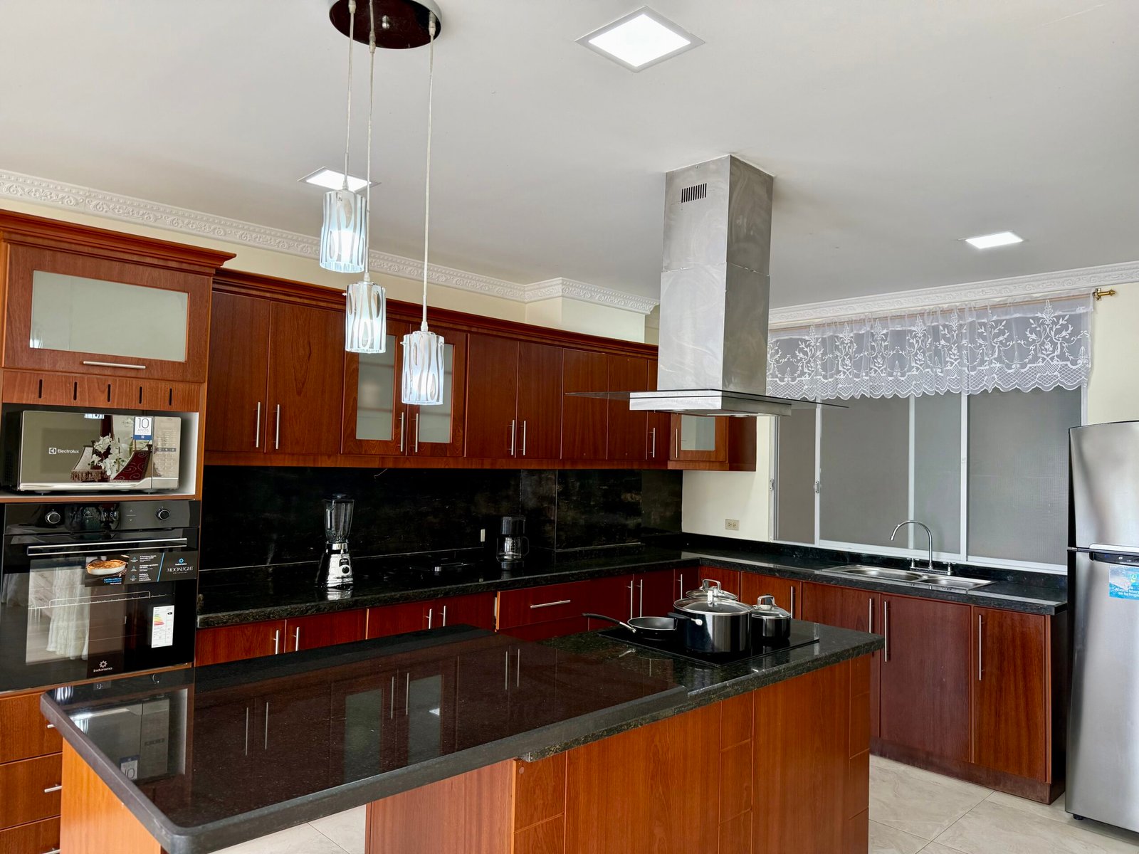 Equipped kitchen with red cabinetry and breakfast bar