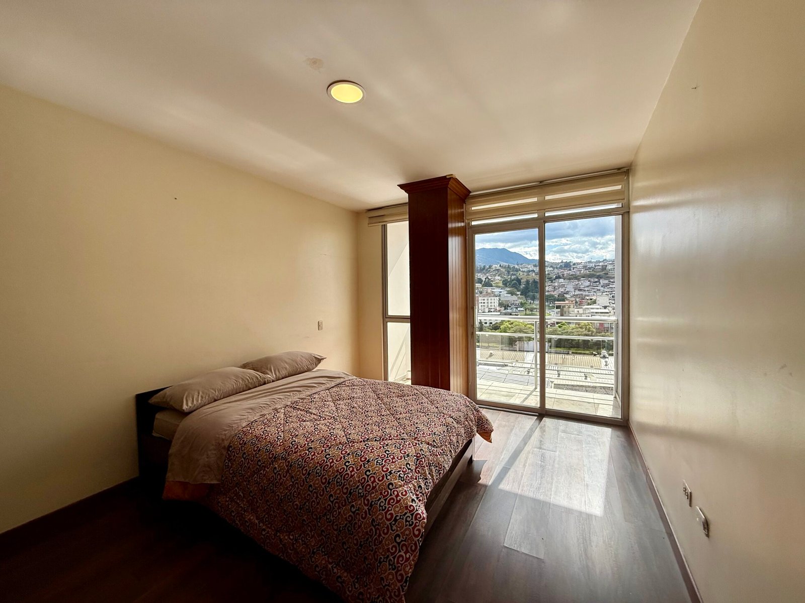 Bedroom with sliding doors to a city-view balcony