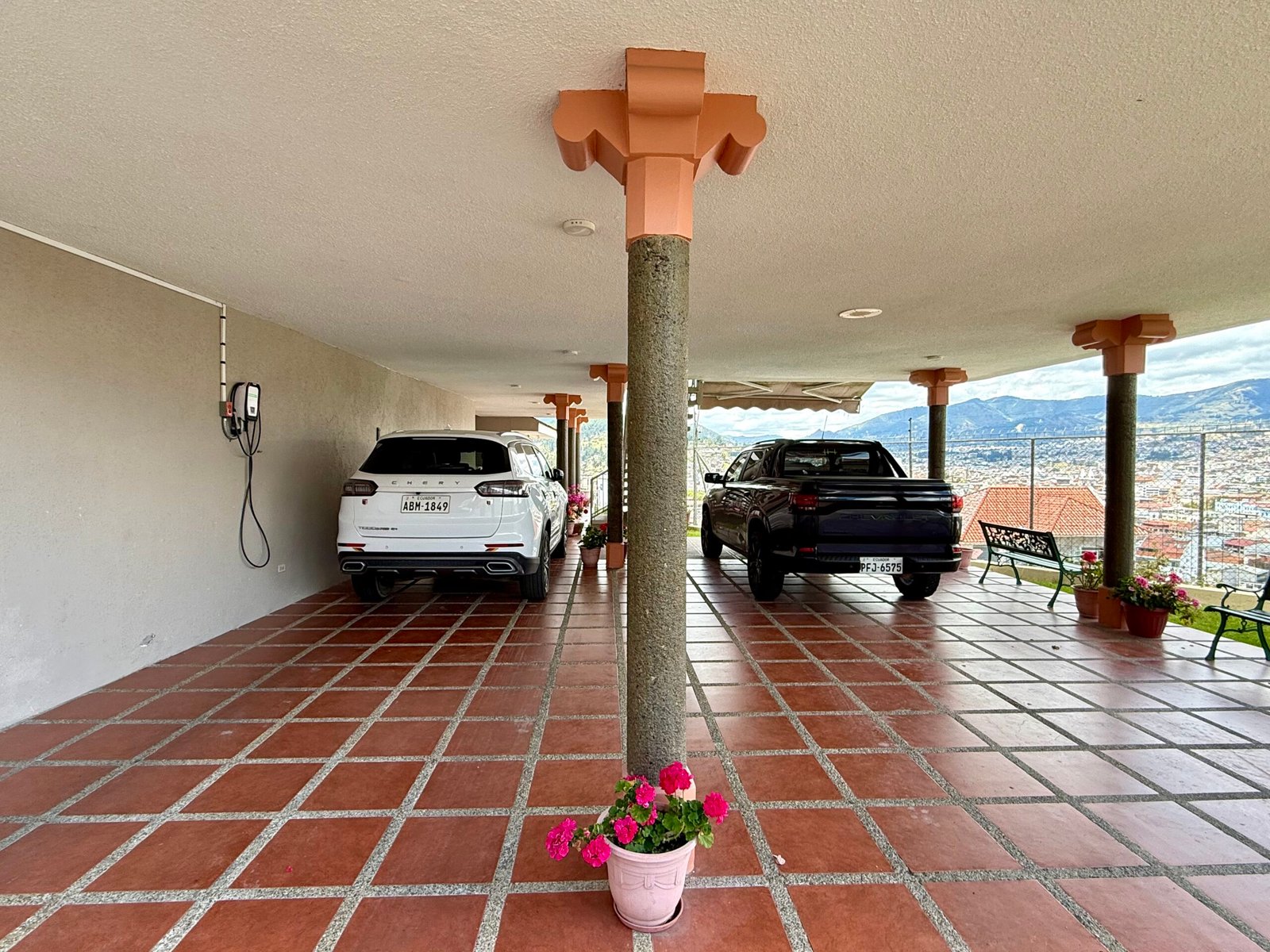 Covered parking area for four vehicles with views across Loja