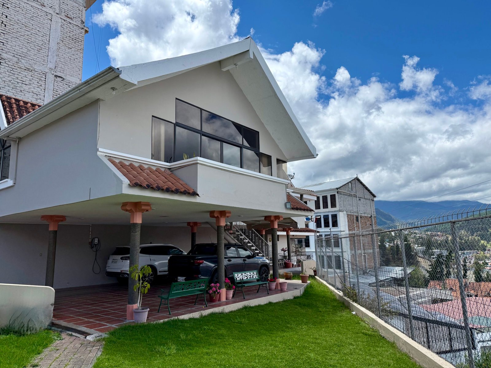 Exterior of the six-bedroom home with lawn and panoramic Loja views