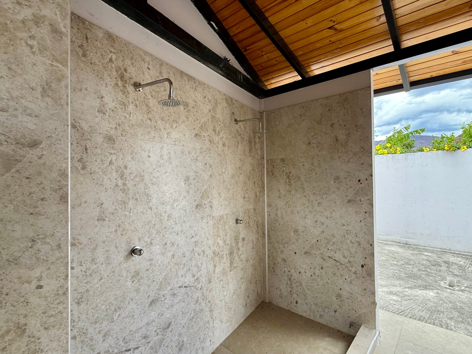 Outdoor shower area beside the swimming pool
