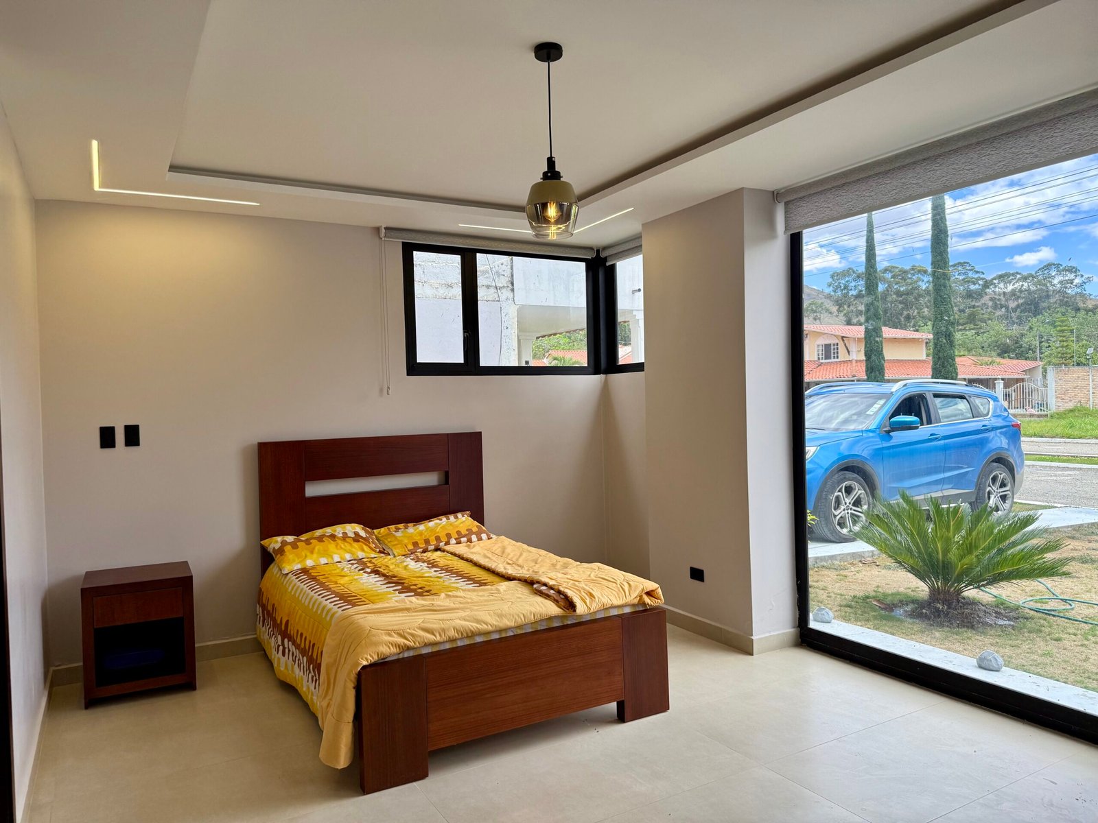 Bedroom with large windows and garden views