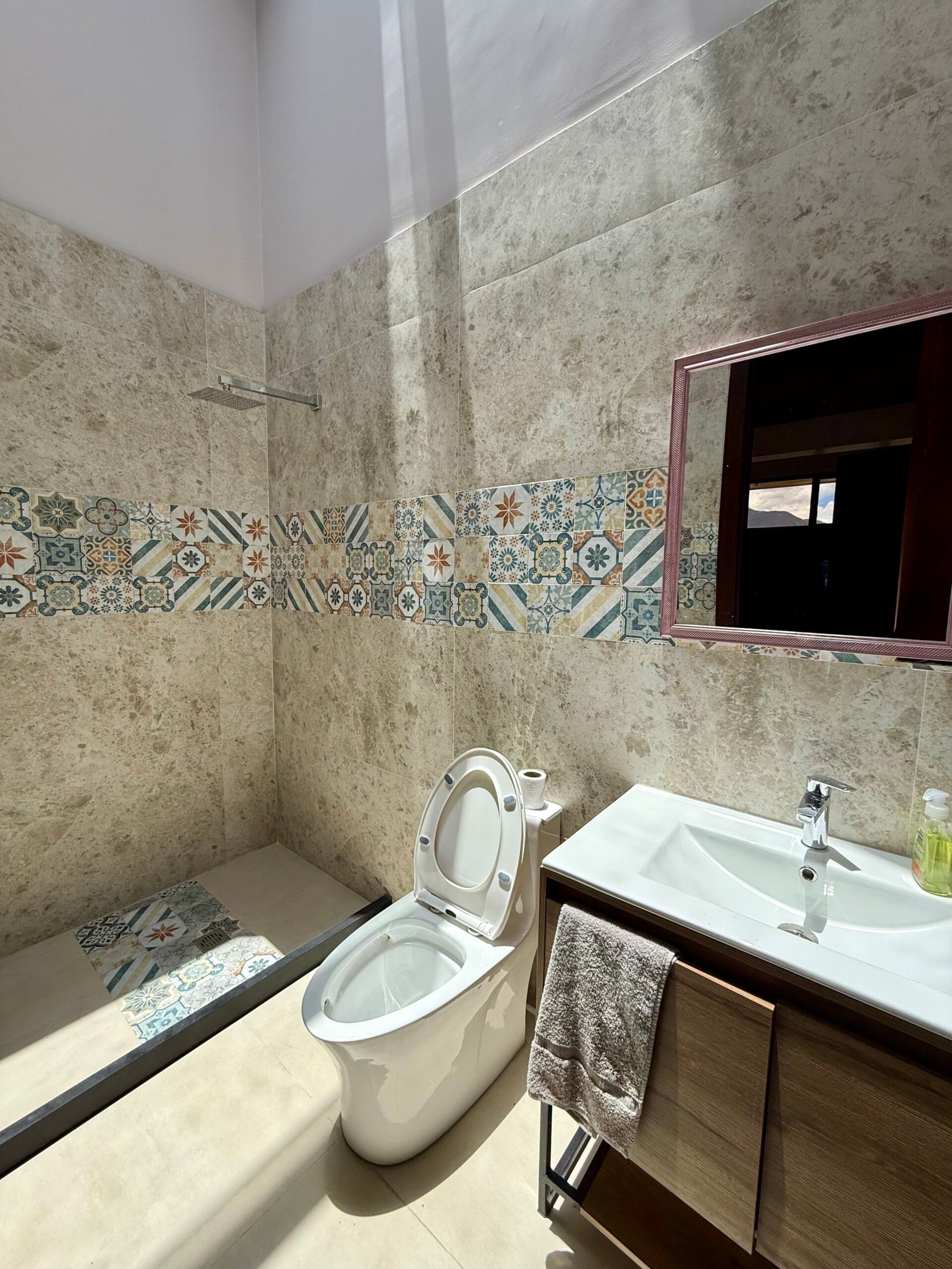 Bathroom vanity with decorative tile and natural light